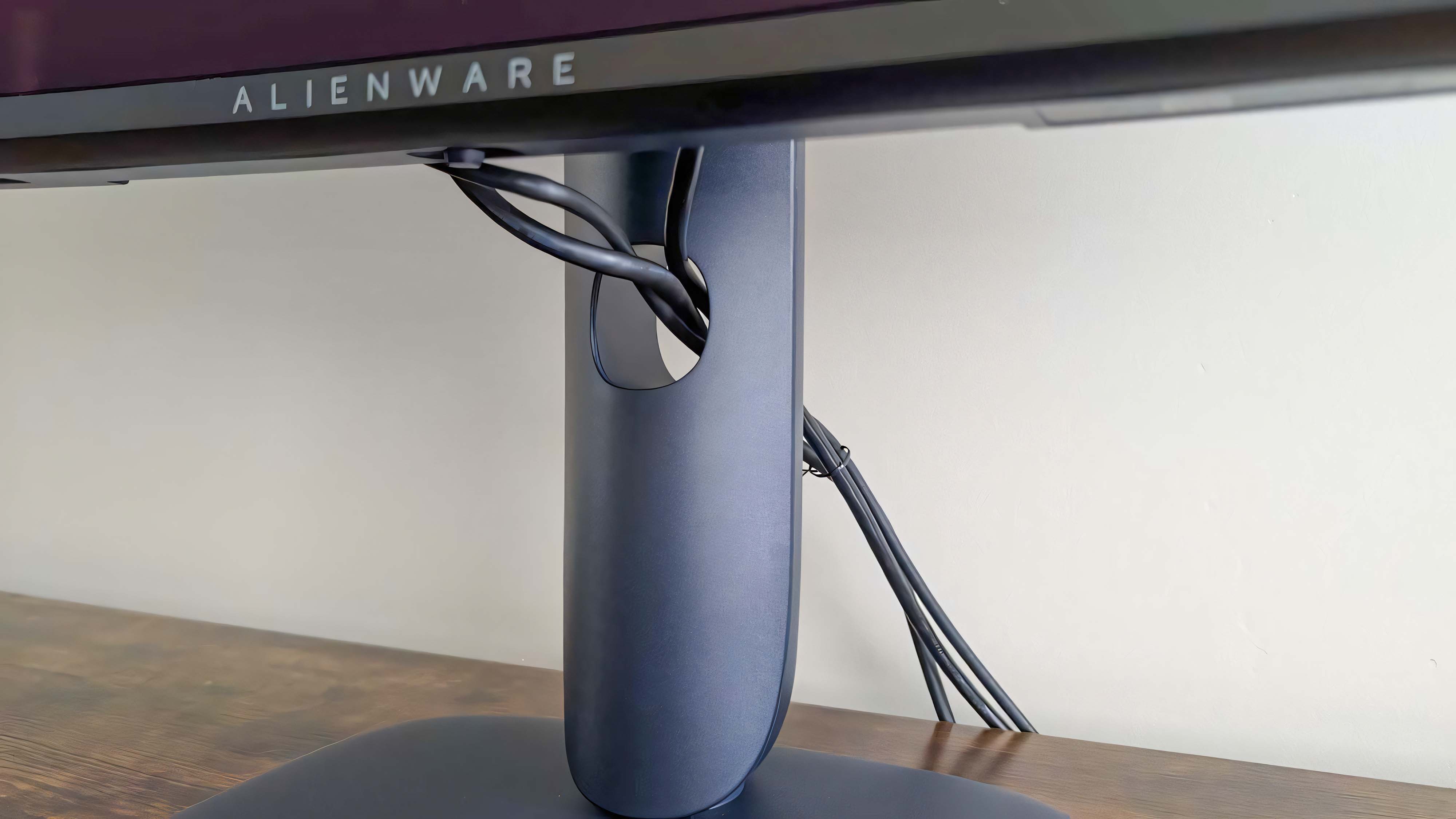 Крупный план кабелей, проходящих через отверстие в подставке Alienware 34" QD-OLED AW3425DW.