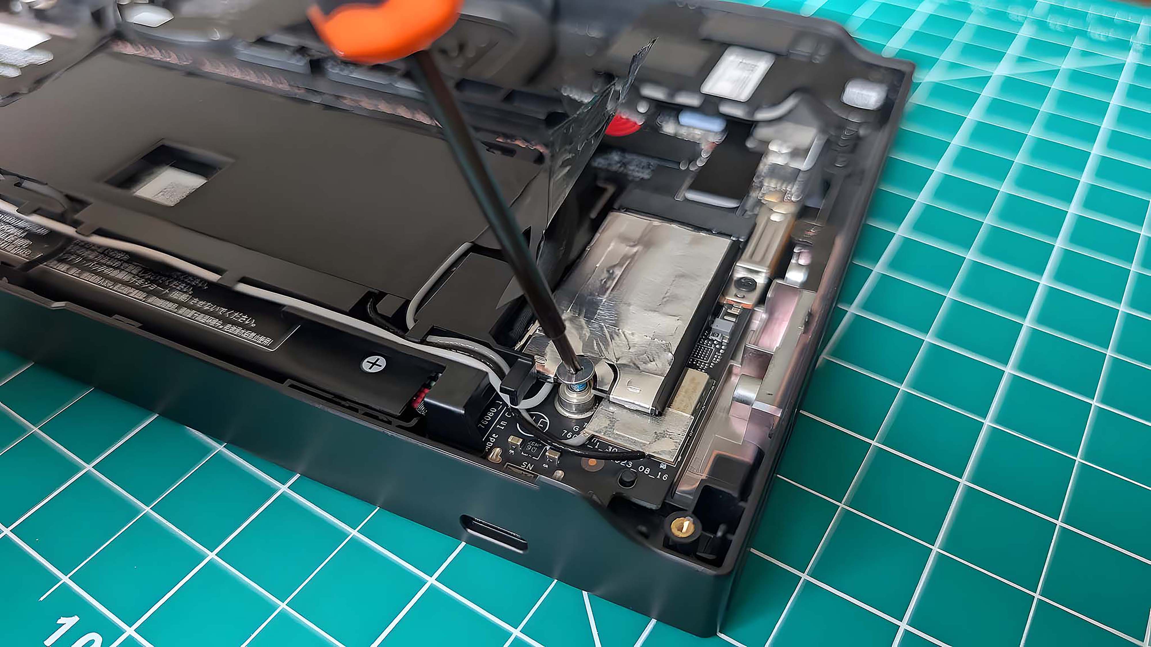 Отвертка откручивает оригинальный винт SSD Lenovo Legion Go.