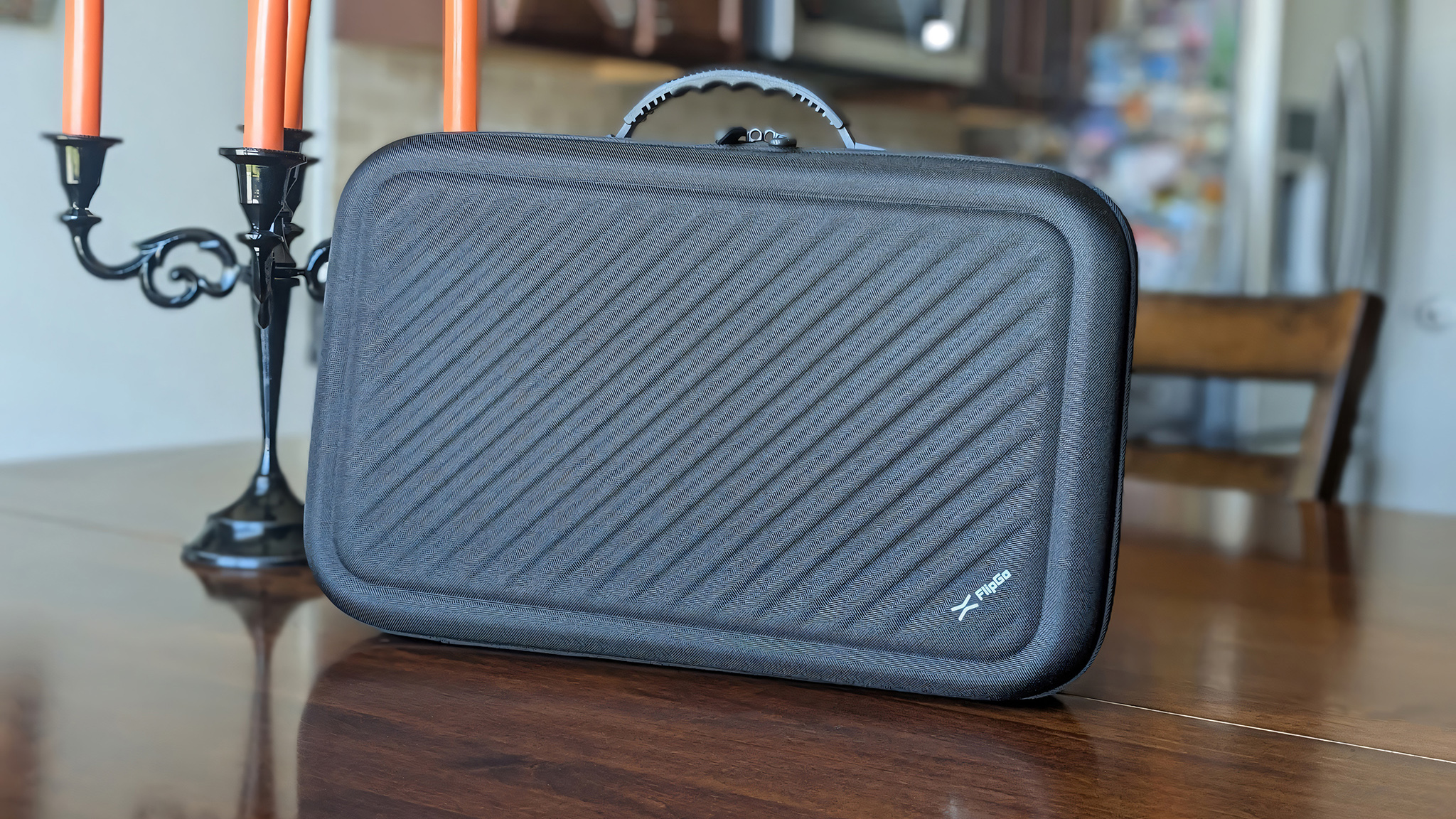 Черный жесткий кейс JSAUX FlipGo Horizon Pro рядом с канделябром
