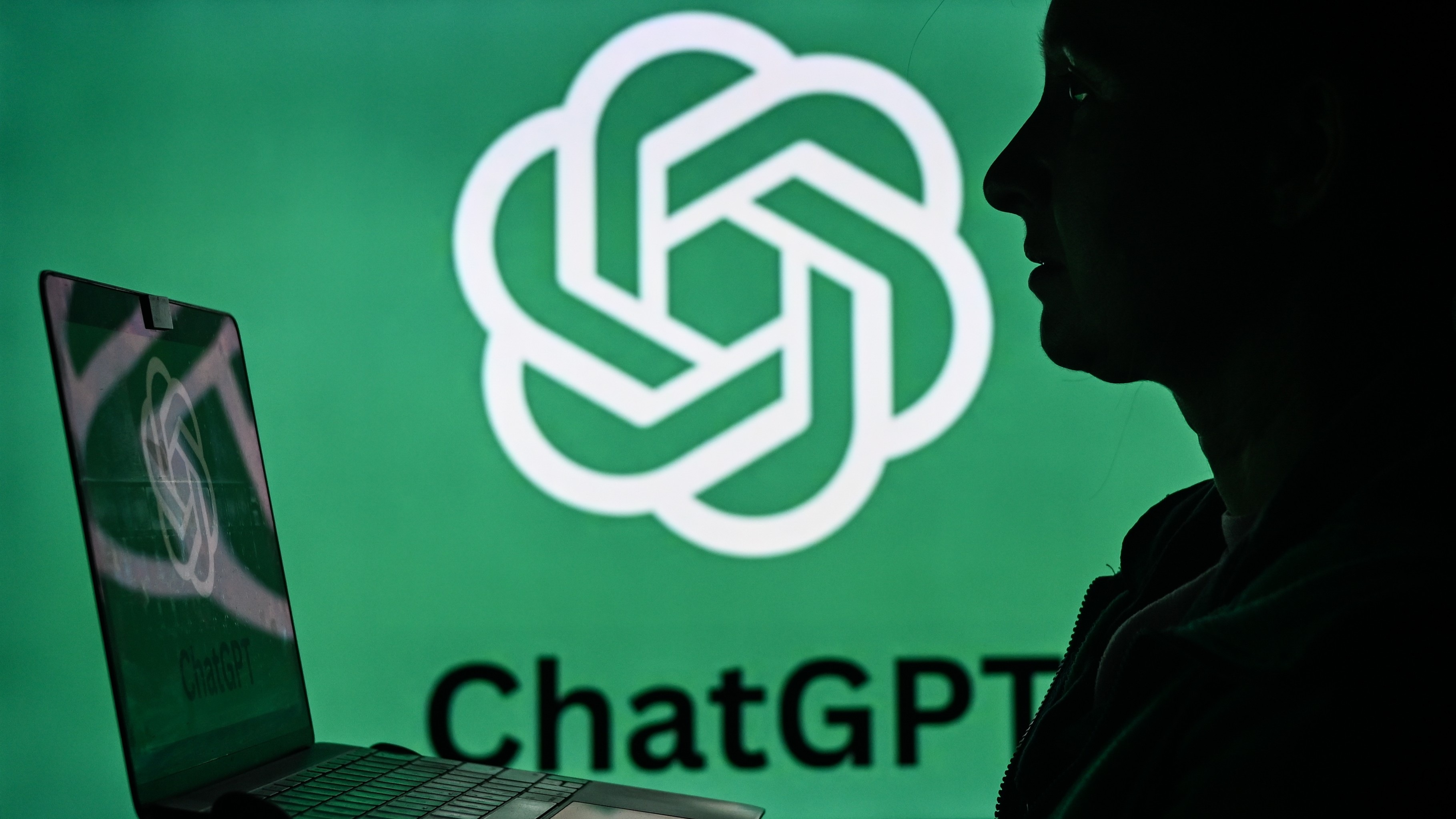 Женщина держит ноутбук, на экране которого отображается логотип ChatGPT.