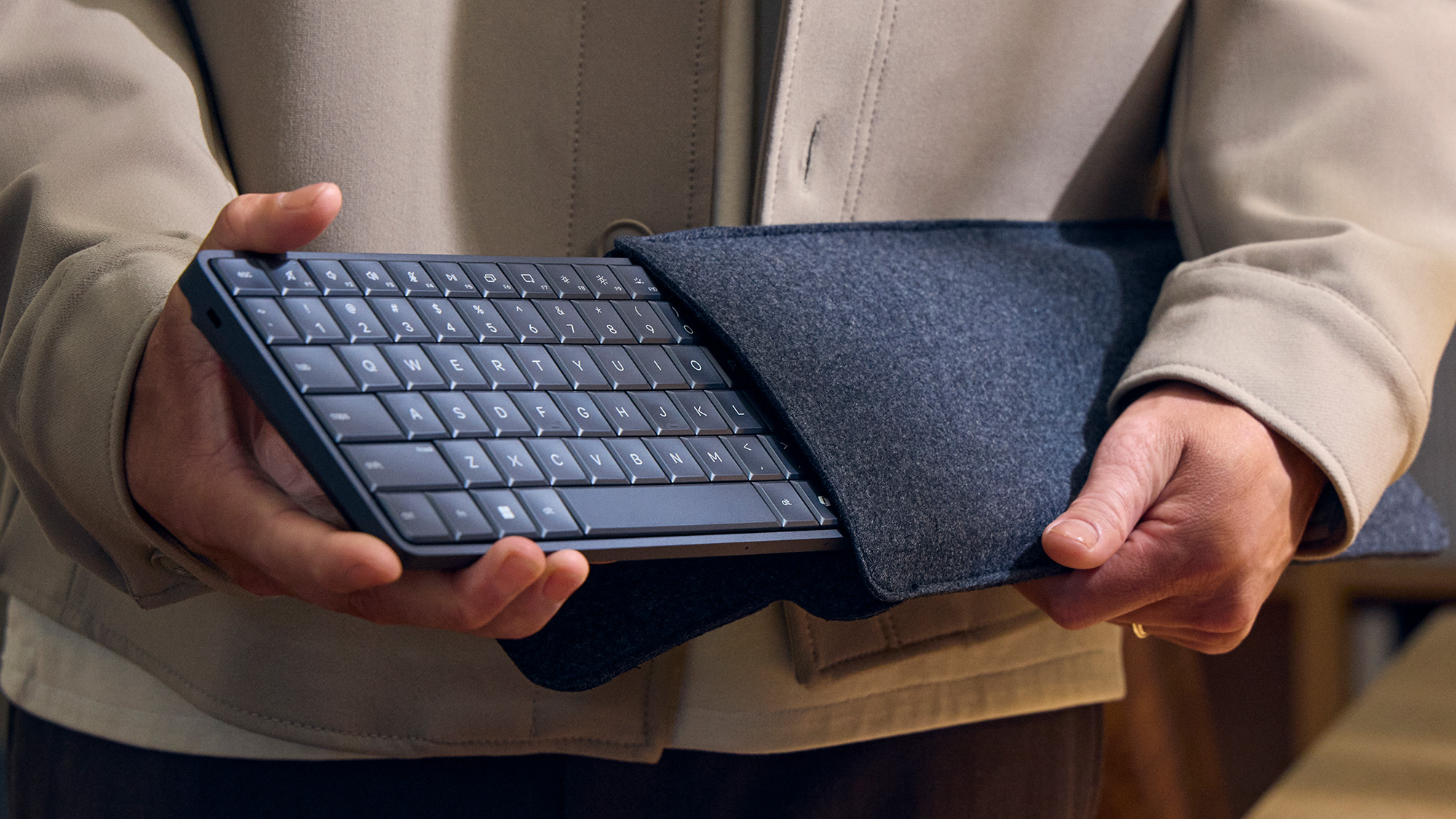 HP EliteBoard G1a Next Gen AI PC held in hand as it's removed from a sleeve