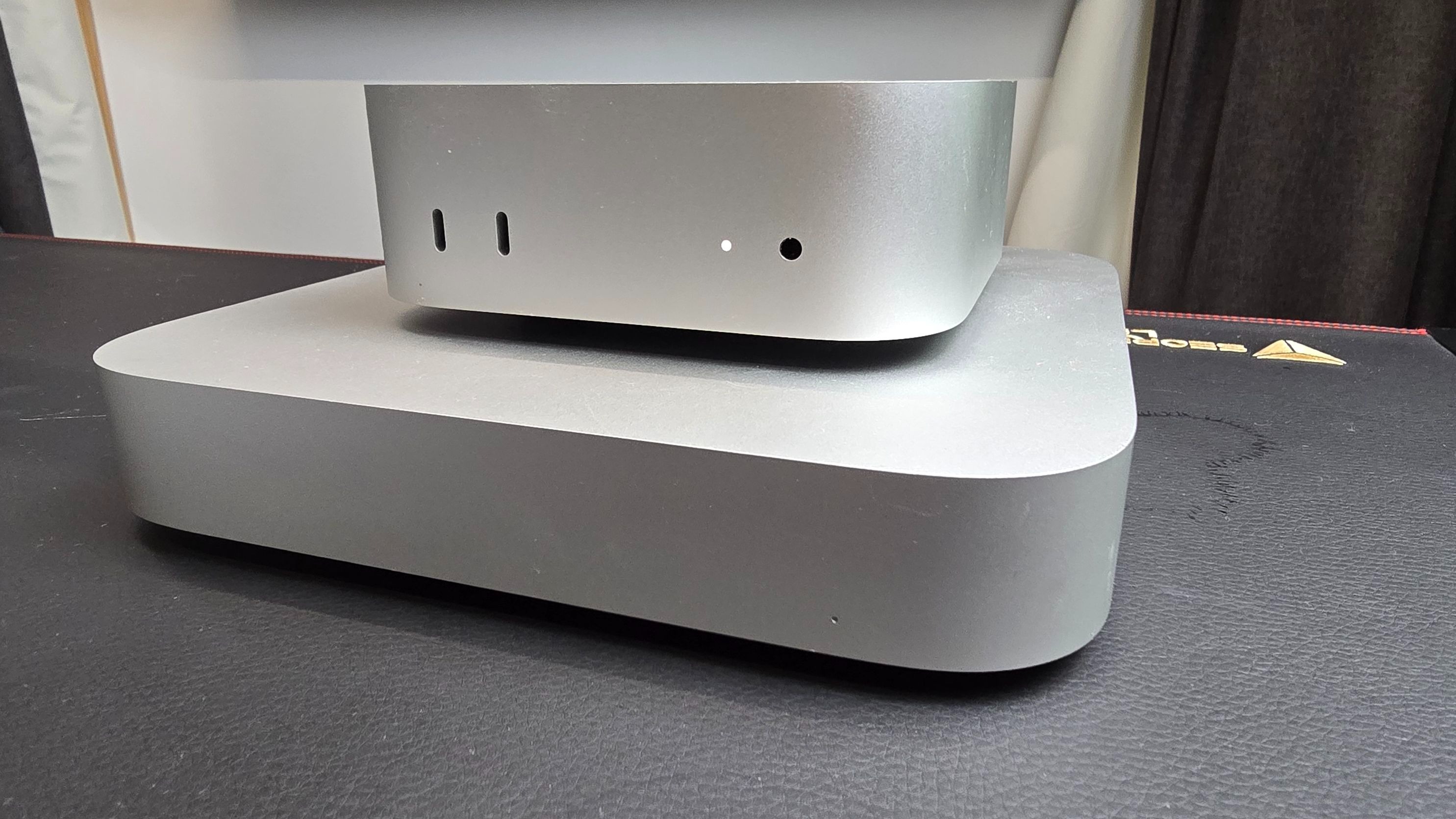 Apple's M4 Mac Mini (2024) stacked on top of the previous version of the Mac Mini.