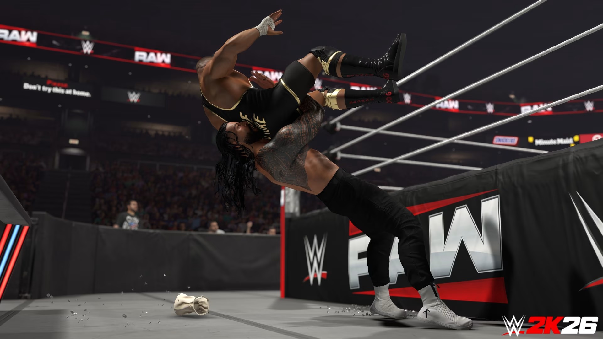 Promotional screenshot of Roman Reigns about to slam Bron Breakker on thumbtacks in WWE 2K26