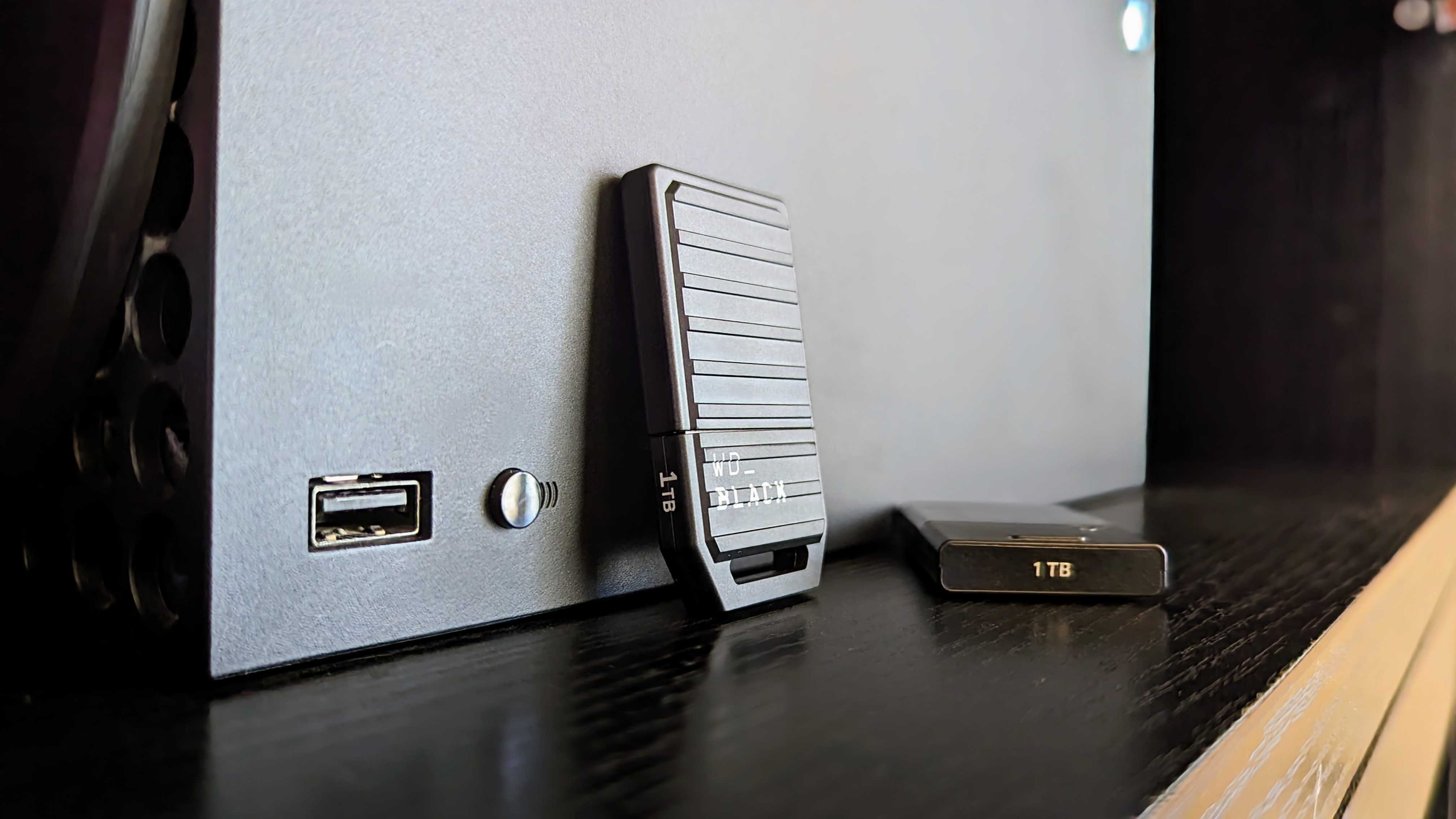 Close-up of an Xbox Series X with a WD_BLACK expansion card and a 1TB storage device on a dark shelf, conveying a tech-savvy atmosphere.