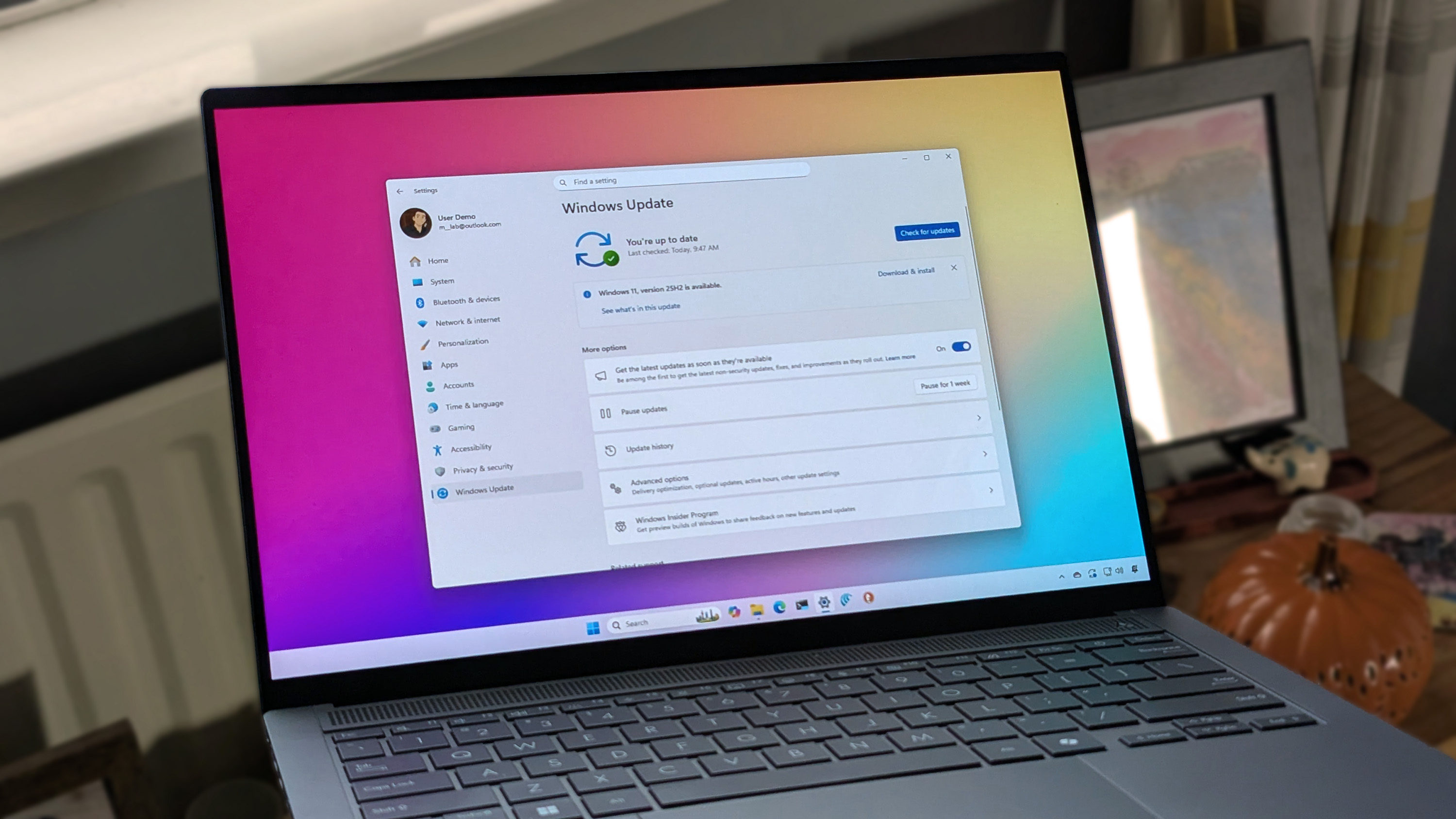ASUS Zenbook 14 OLED laptop displaying Windows 11 with Windows Update screen